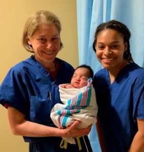 Dr. Favor with pre-medical student and newborn