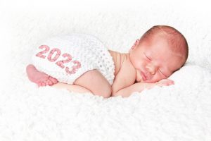 sleeping newborn with 2023 on diaper cover