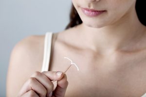 Young woman holding IUD